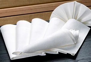 A set of elegantly folded white napkins arranged in various decorative styles on a dark surface
